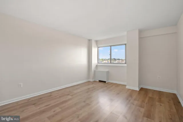 a view of a kitchen with wooden floor and a window