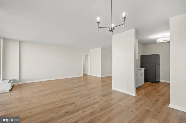 a view of a kitchen with a refrigerator and a wooden floor