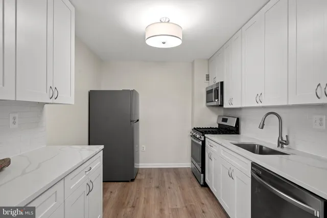 a kitchen with a sink a stove a refrigerator and cabinets