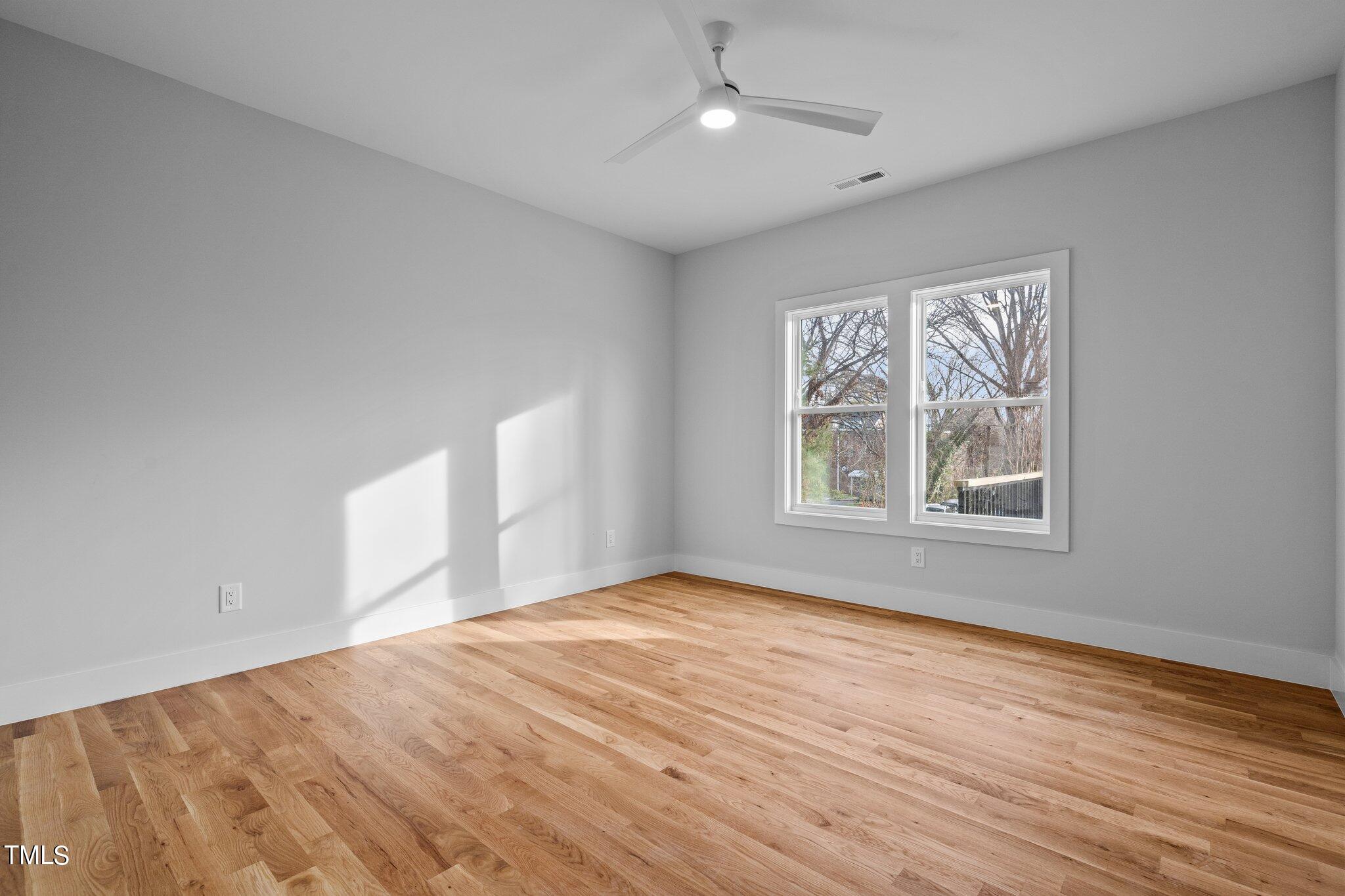 421 Harding Street Raleigh, NC 27604 - Photo 11 of 50 a view of an empty room with window and wooden floor