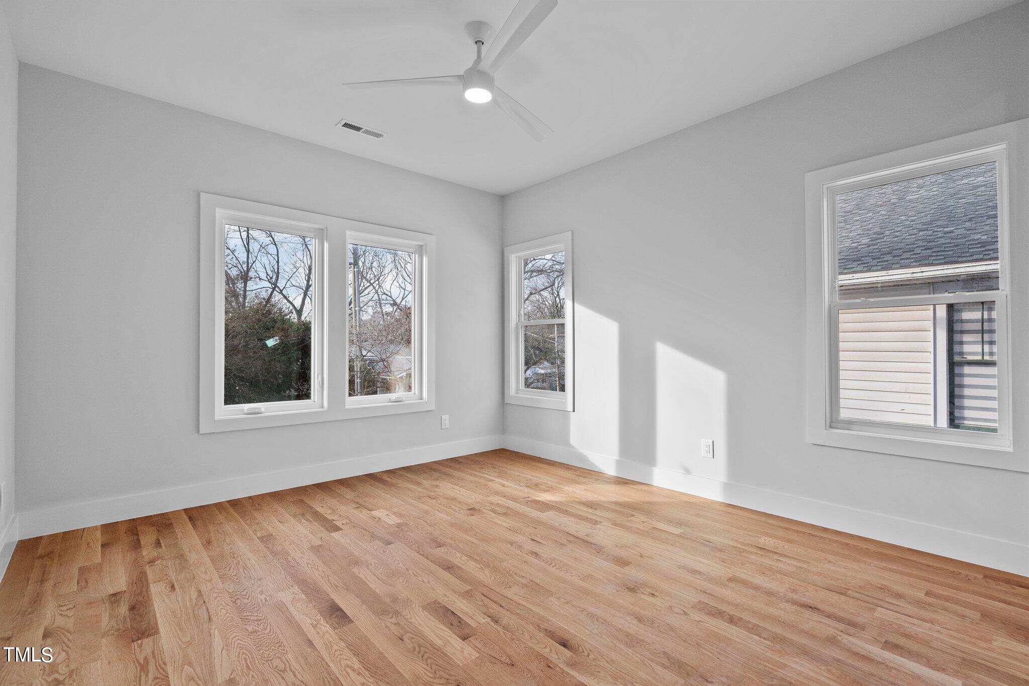 421 Harding Street Raleigh, NC 27604 - Photo 7 of 50 a view of an empty room with wooden floor and a window