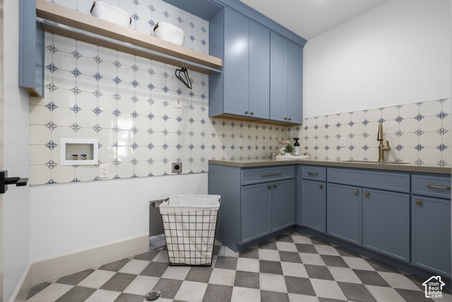 1175 North Elk Rdg Lane, Unit 201 Alpine, UT 84004 - Photo 6 of 38 Blue cabinetry with brass hardware, patterned tile backsplash, light wood shelving, neutral countertops, and checkerboard floor tile