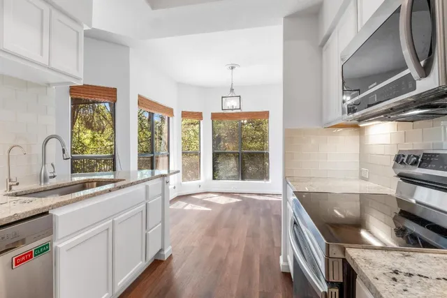 a view of a kitchen with a sink and wooden floor