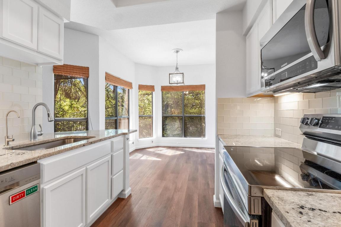 4711 Spicewood Springs Road, Unit 166 Austin, TX 78759 - Photo 12 of 25 a view of a kitchen with a sink and wooden floor