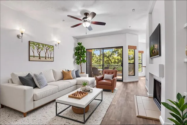 a living room with furniture fireplace and a large window
