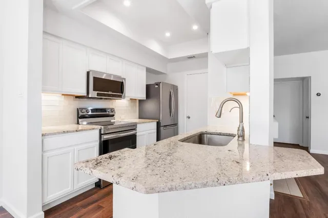 a kitchen with kitchen island a sink appliances and cabinets