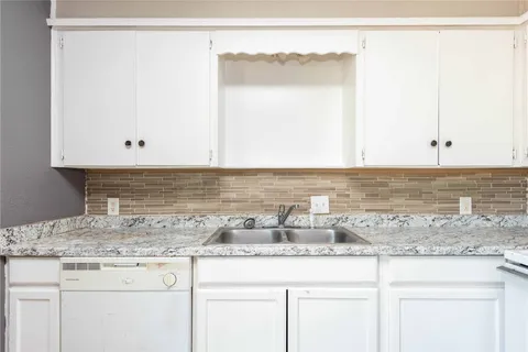 a view of a kitchen with granite countertop cabinets