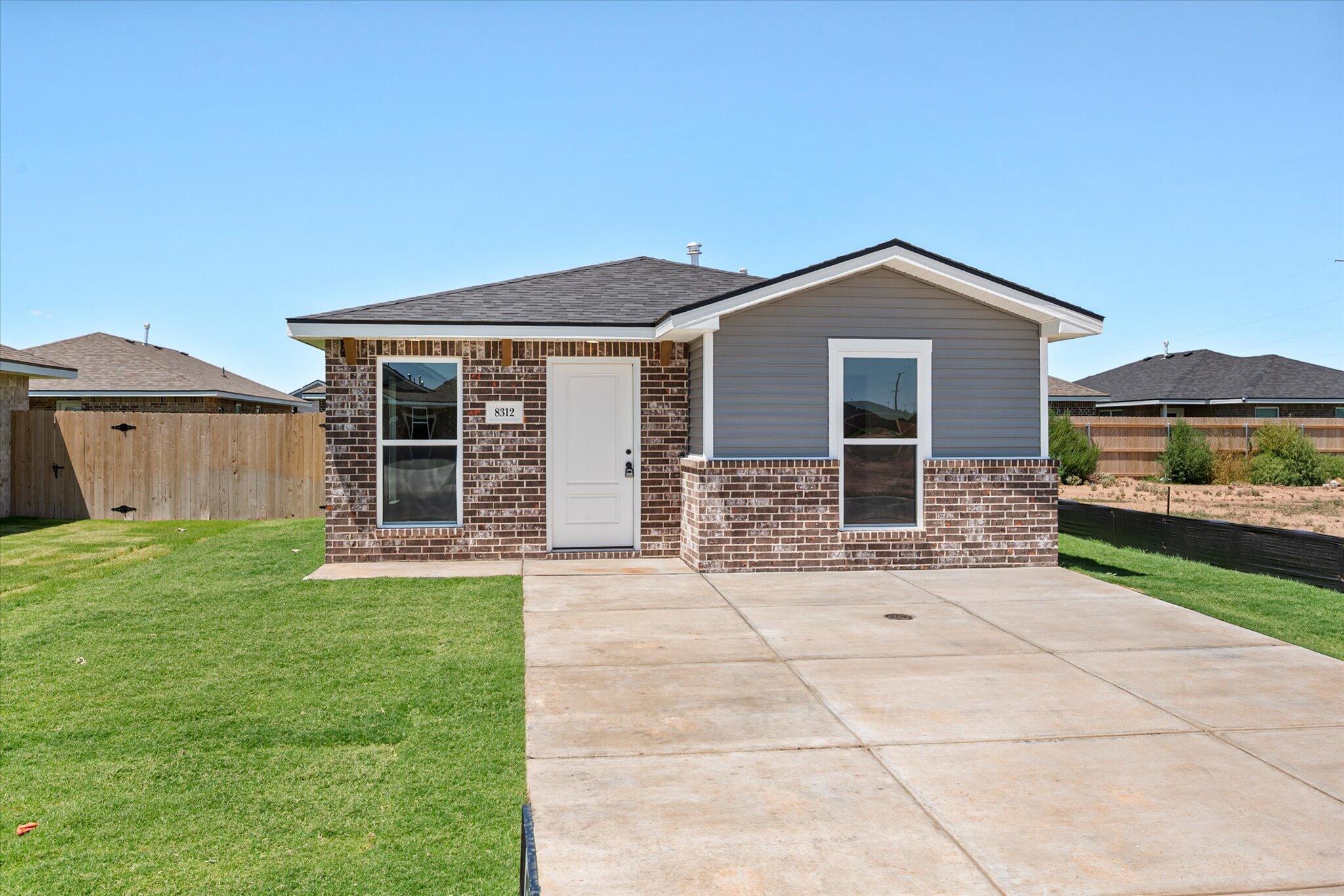 8312 25th Street Lubbock, TX 79407 - Photo 2 of 17 a front view of a house with garden