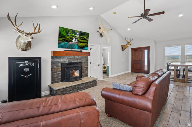 1588 West Rim Rock Drive Stockton, UT 84071 - Photo 4 of 61 Vaulted ceiling with a ceiling fan, recessed lighting, and a stone-clad fireplace with a wood mantel