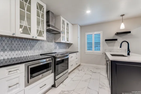 a kitchen with granite countertop a stove and a sink