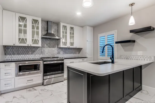 a kitchen with stainless steel appliances granite countertop a sink stove and cabinets