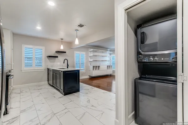 a kitchen with granite countertop a refrigerator and a stove top oven