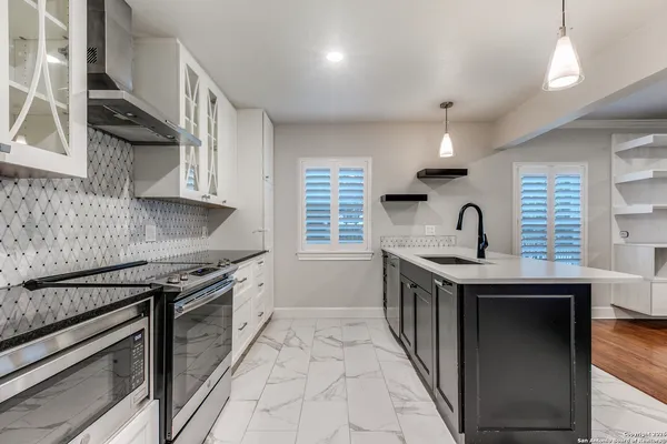 a kitchen with stainless steel appliances granite countertop a sink stove and cabinets