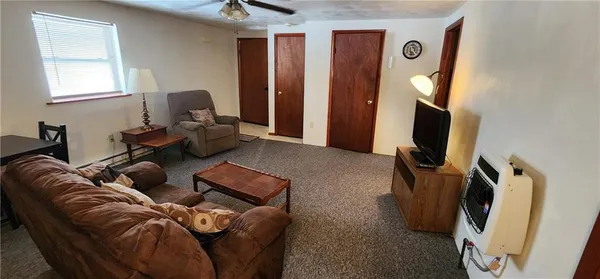a living room with furniture a flat screen tv and a window