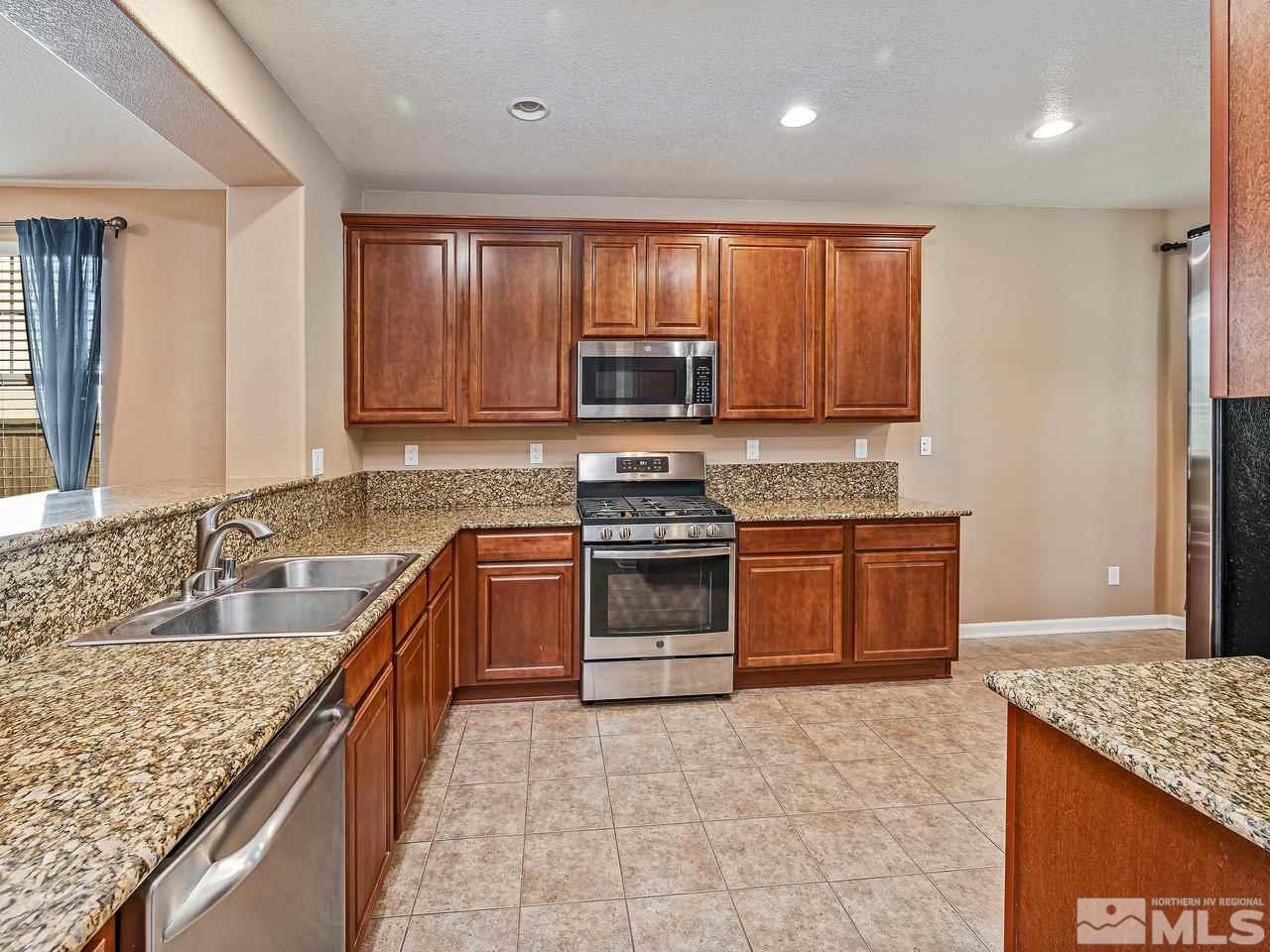 560 Little Sorrel Court Reno, NV 89521 - Photo 4 of 16 a kitchen with stainless steel appliances granite countertop a stove a sink and a microwave