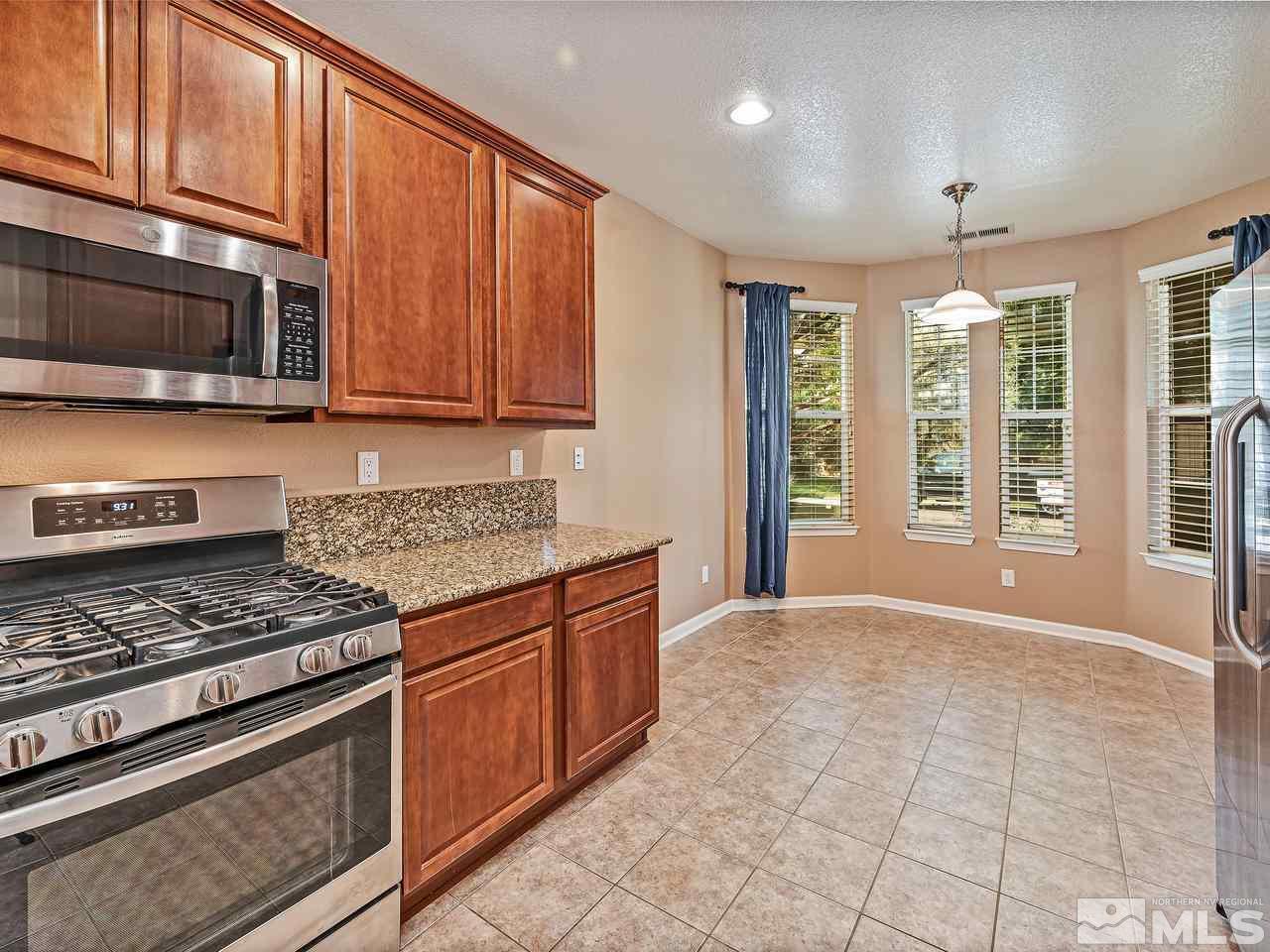 560 Little Sorrel Court Reno, NV 89521 - Photo 5 of 16 a kitchen with stainless steel appliances granite countertop a stove a sink and a microwave