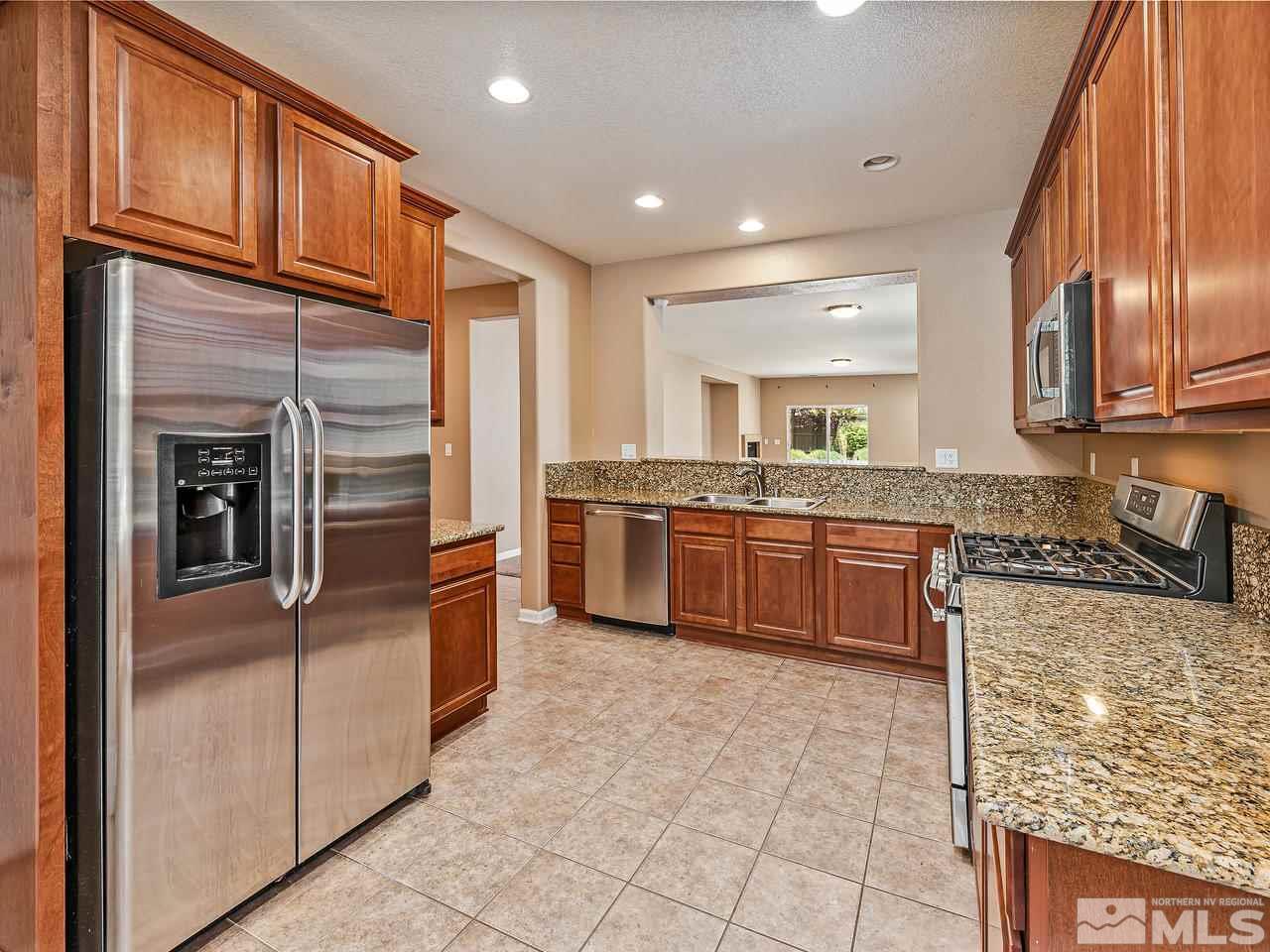 560 Little Sorrel Court Reno, NV 89521 - Photo 6 of 16 a large kitchen with stainless steel appliances granite countertop a stove refrigerator and cabinets