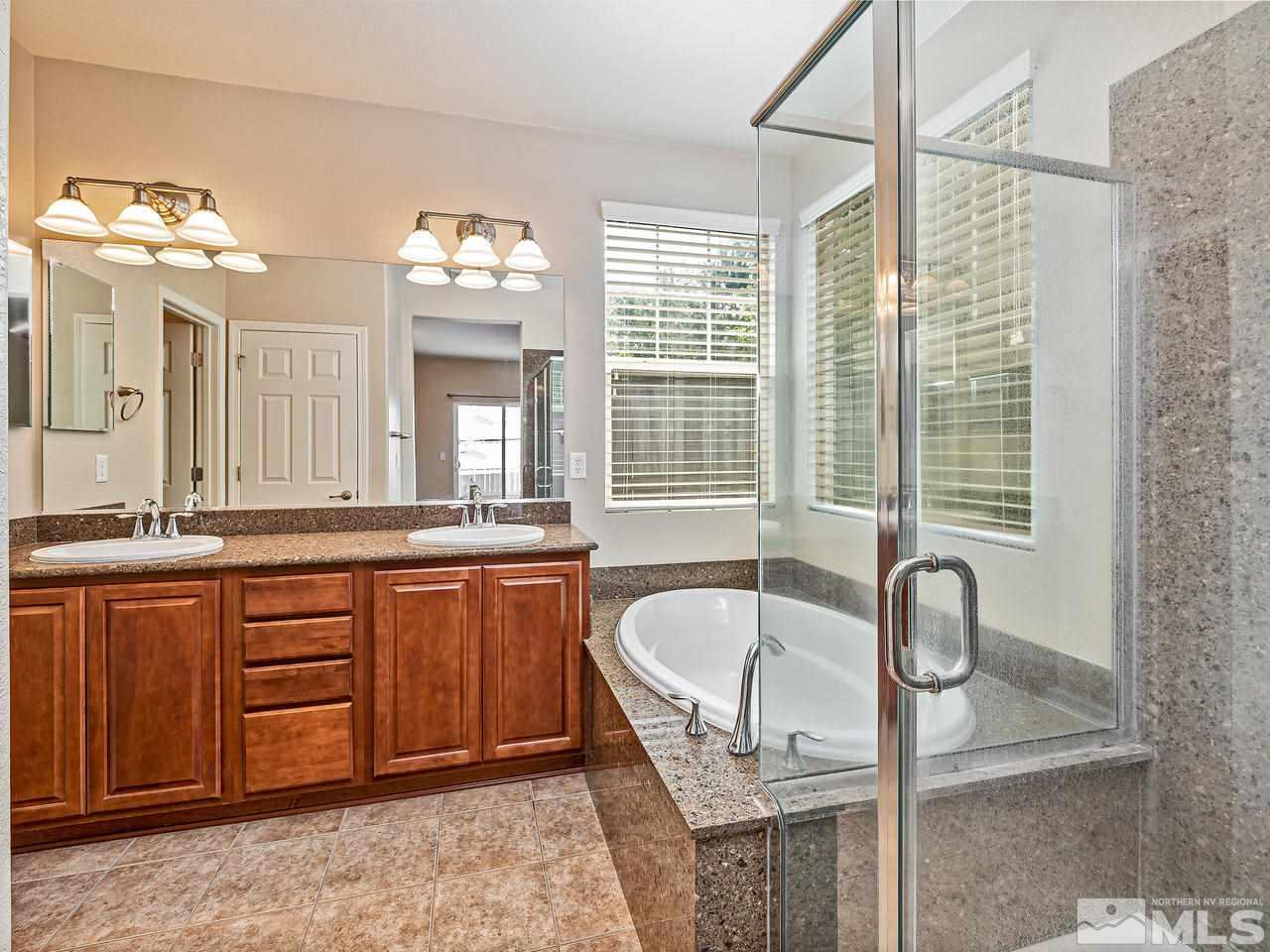 560 Little Sorrel Court Reno, NV 89521 - Photo 10 of 16 a spacious bathroom with a granite countertop tub sink and mirror