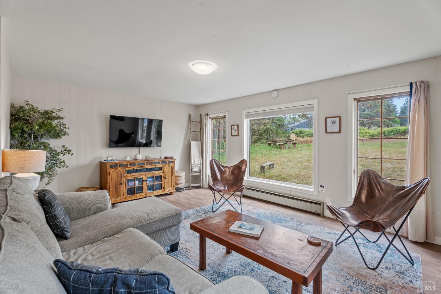 15741 Forest View Road Manchester, CA 95459 - Photo 1 of 28 a living room with furniture a flat screen tv and a window