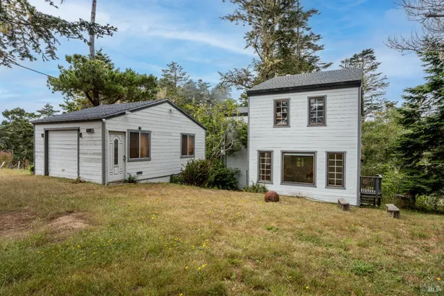a front view of a house with yard and trees