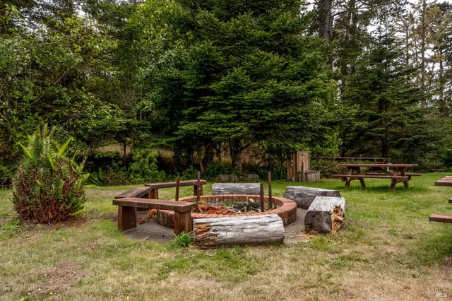 a view of a backyard with lawn chairs and a fire pit