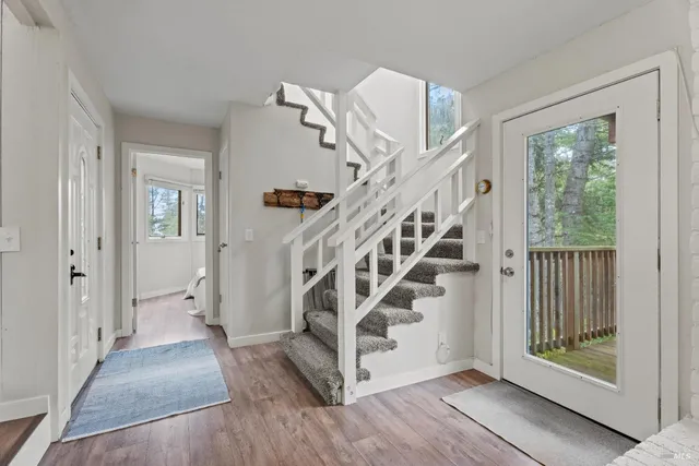 a view of entryway with wooden floor and a front door