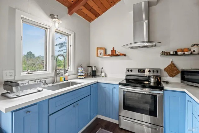 a kitchen with stainless steel appliances a stove a sink and a window