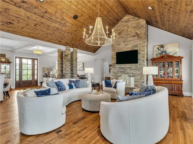a kitchen with stainless steel appliances granite countertop a stove refrigerator and chairs