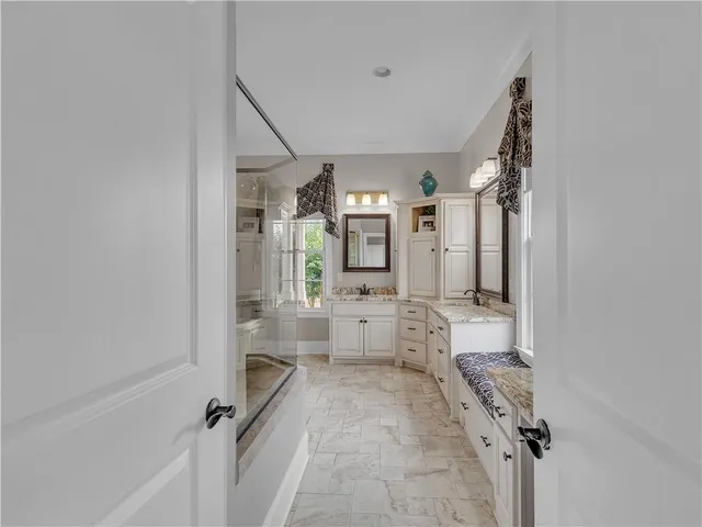 a bathroom with a granite countertop toilet a sink and a mirror
