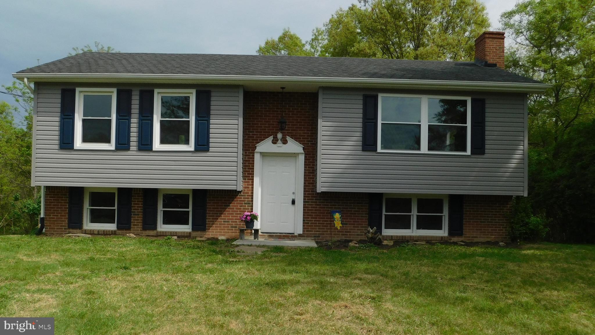205 Guard Road Middletown, VA 22645 - Photo 1 of 26 a view of a brick house with a large window and a yard
