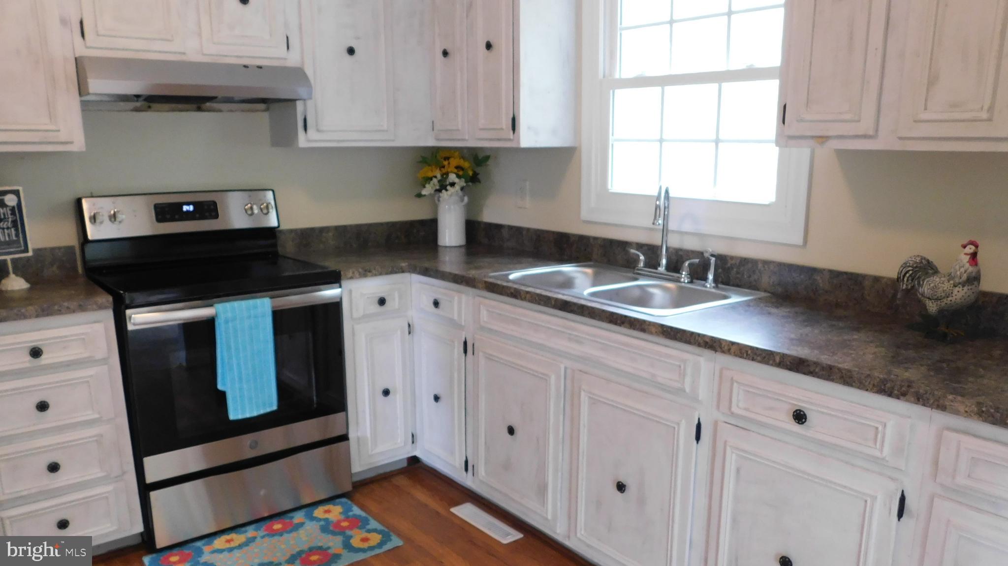 205 Guard Road Middletown, VA 22645 - Photo 9 of 26 a kitchen with granite countertop white cabinets stainless steel appliances and a window