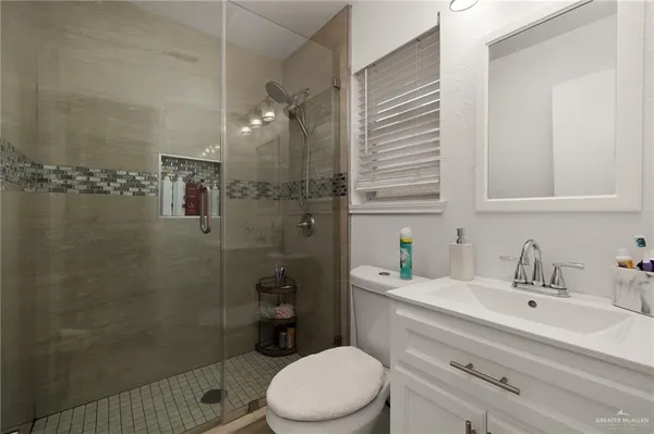 a bathroom with a sink a toilet and shower