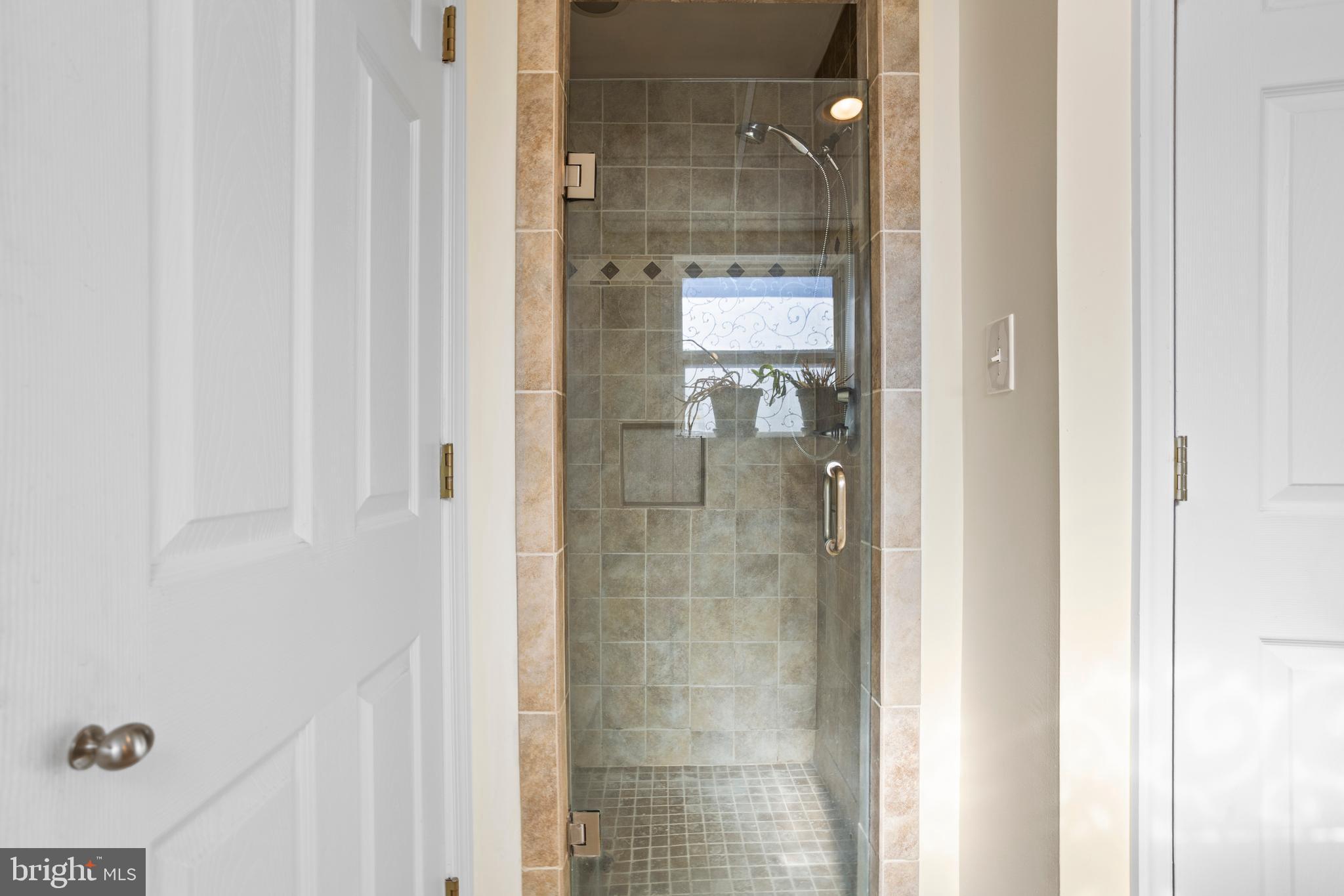 7410 Dakota Avenue Chesapeake Beach, MD 20732 - Photo 40 of 68 a bathroom with a glass shower door