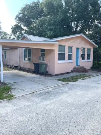 a front view of house with yard and trees in the background