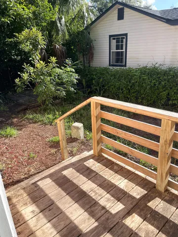 a view of backyard with deck and garden