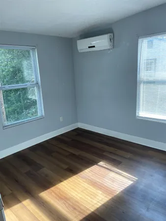 a view of a room with wooden floor and windows