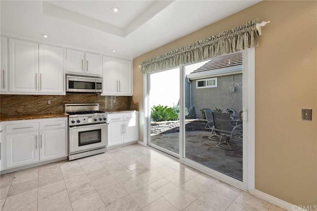5 Elderwood, Unit 19 Irvine, CA 92614 - Photo 12 of 39 a kitchen with granite countertop a stove top oven microwave and cabinets