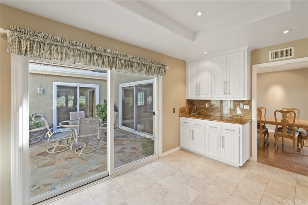 5 Elderwood, Unit 19 Irvine, CA 92614 - Photo 16 of 39 a kitchen with white cabinets and dining table