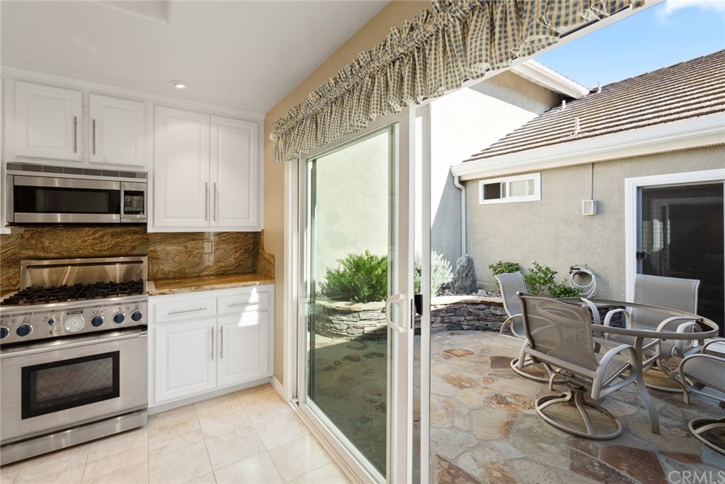 5 Elderwood, Unit 19 Irvine, CA 92614 - Photo 17 of 39 a kitchen with granite countertop a stove a sink and a microwave