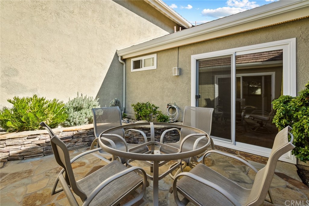 5 Elderwood, Unit 19 Irvine, CA 92614 - Photo 18 of 39 a view of a patio with table and chairs potted plants with wooden floor and fence