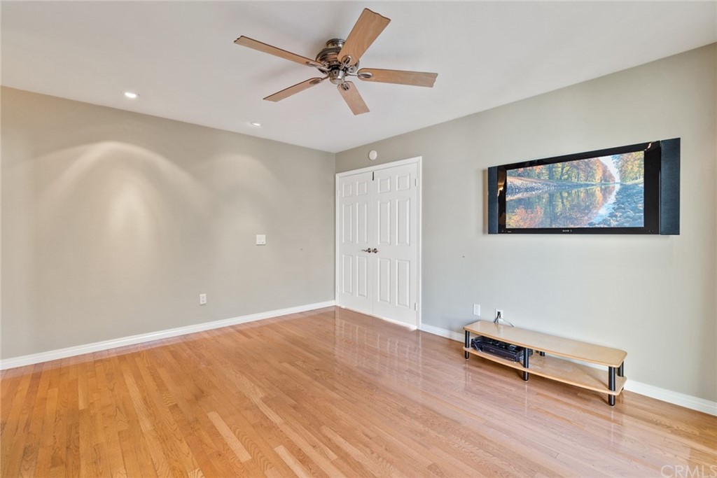 5 Elderwood, Unit 19 Irvine, CA 92614 - Photo 30 of 39 a view of room with hardwood floor and a ceiling fan