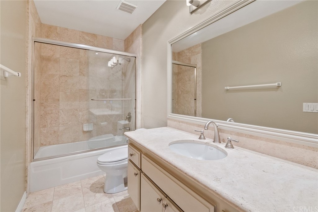 5 Elderwood, Unit 19 Irvine, CA 92614 - Photo 34 of 39 a bathroom with a granite countertop sink a toilet and shower