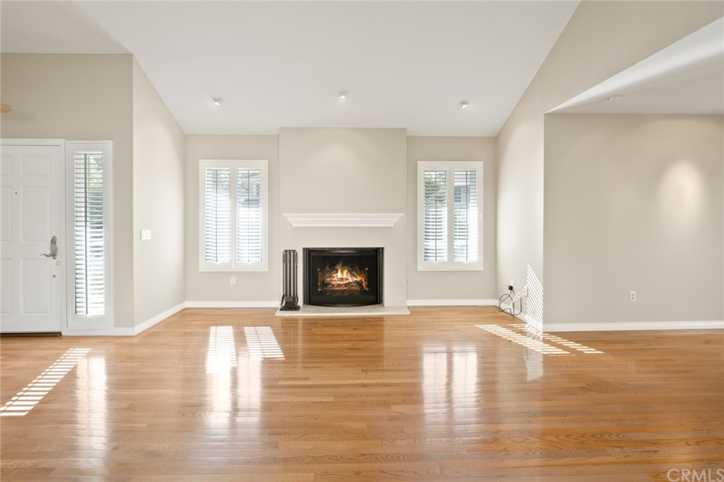 5 Elderwood, Unit 19 Irvine, CA 92614 - Photo 6 of 39 a view of a livingroom with wooden floor and a fireplace