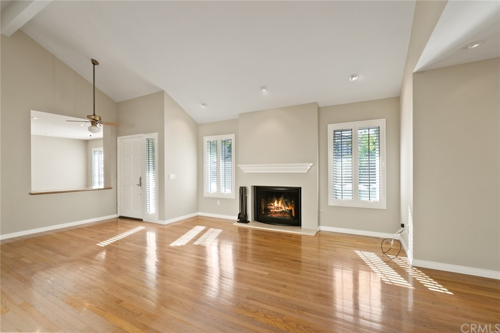 5 Elderwood, Unit 19 Irvine, CA 92614 - Photo 8 of 39 a view of empty room with wooden floor fireplace and windows