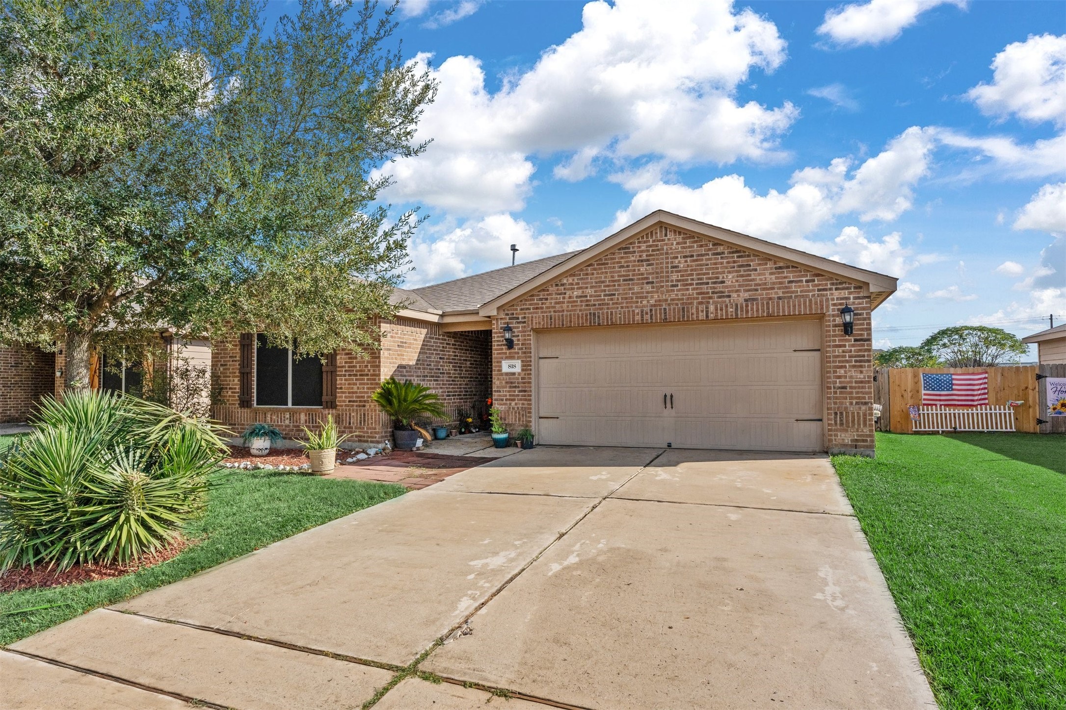 a front view of a house with a garden and trees