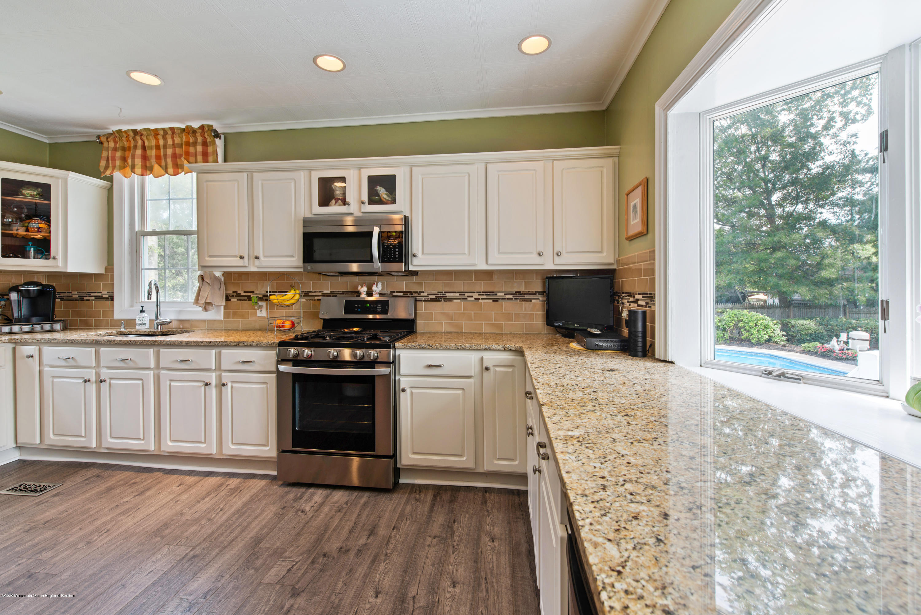 205 Main Street Keyport, NJ 07735 - Photo 9 of 42 a kitchen with granite countertop a stove top oven a sink dishwasher and a refrigerator with wooden floors