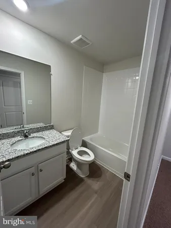 a bathroom with a granite countertop sink toilet a mirror and shower