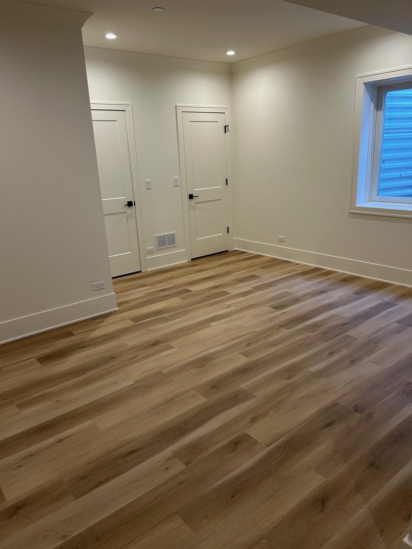 1413 Brophy Avenue Park Ridge, IL 60068 - Photo 32 of 34 an empty room with wooden floor and windows