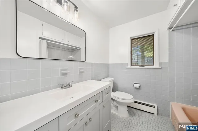 a bathroom with a sink a toilet and mirror