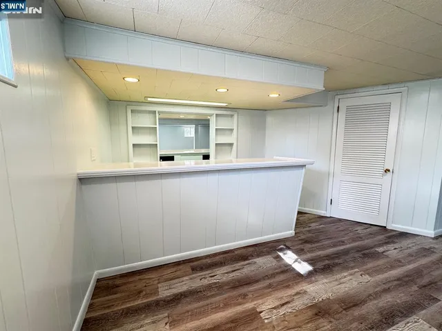 an empty room with wooden floor and white wall